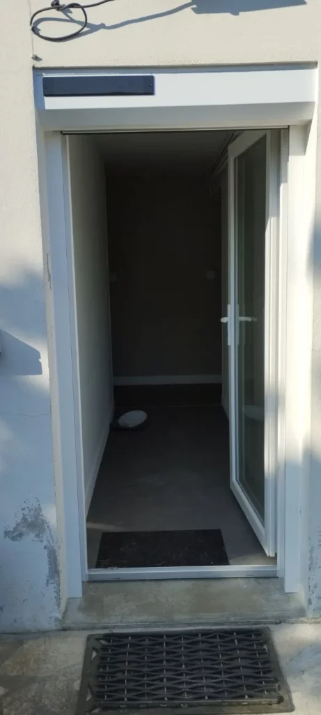 Pose de volet roulant rénovation avec panneau solaire au-dessus d'une porte vitrée en PVC à Bergerac.