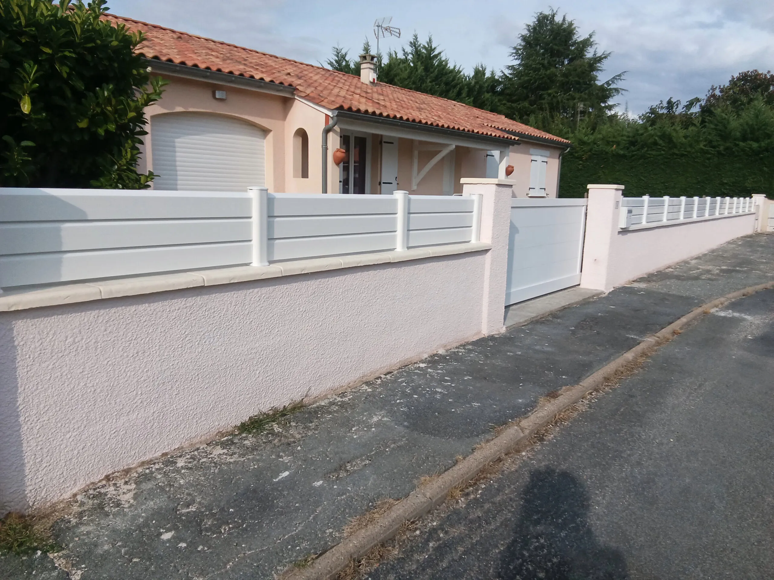 Ensemble portail coulissant plein blanc et clôture sur muret, rénovation menuiserie extérieure à Bergerac par Baies & Bastide.