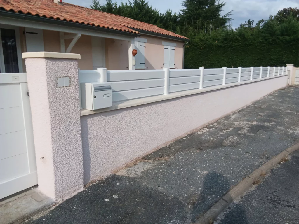 Clôture brise-vue blanche à lames horizontales posée sur muret, installation sur mesure en Dordogne.